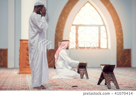 Two religious muslim man praying together inside the mosque 41070414