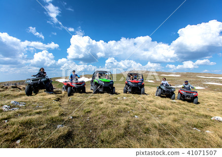 Friends driving off-road with quad bike or ATV and UTV vehicles 41071507