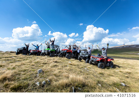 Friends driving off-road with quad bike or ATV and UTV vehicles 41071516