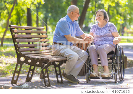 Elderly man strengthens his wife in the wheelchair Elderly man strengthens his wife in the wheelchair 41071635