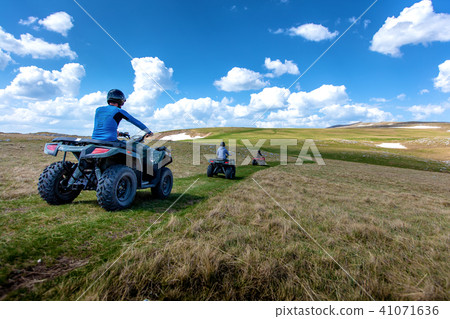 Friends driving off-road with quad bike or ATV and UTV vehicles Friends driving off-road with quad bike or ATV and UTV vehicles 41071636