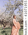 Girl in a pink dress is posing in a garden full  41071955