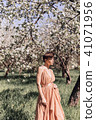 Girl in a pink dress is posing in a garden full  41071956