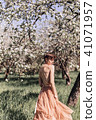 Girl in a pink dress is posing in a garden full  41071957