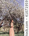 Girl in a pink dress is posing in a garden full  41071959
