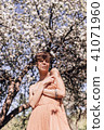 Girl in a pink dress is posing in a garden full  41071960