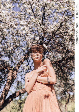 Girl in a pink dress is posing in a garden full Girl in a pink dress is posing in a garden full 41071960