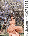 Girl in a pink dress is posing in a garden full  41071961