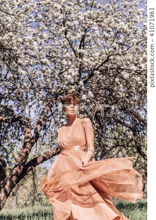 Girl in a pink dress is posing in a garden full  41071961