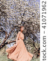 Girl in a pink dress is posing in a garden full  41071962