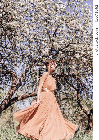 Girl in a pink dress is posing in a garden full  41071962