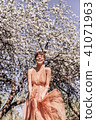 Girl in a pink dress is posing in a garden full  41071963