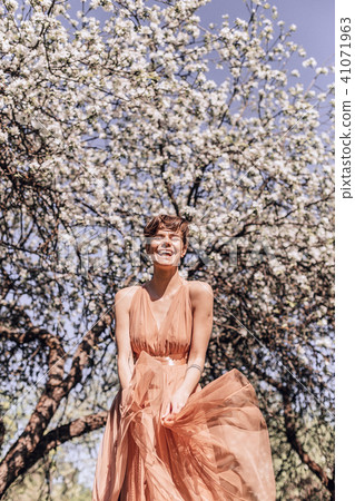 Girl in a pink dress is posing in a garden full Girl in a pink dress is posing in a garden full 41071963