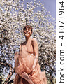 Girl in a pink dress is posing in a garden full  41071964