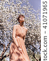 Girl in a pink dress is posing in a garden full  41071965