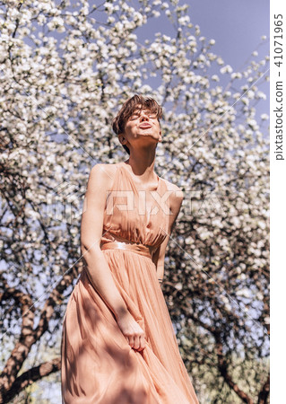 Girl in a pink dress is posing in a garden full Girl in a pink dress is posing in a garden full 41071965