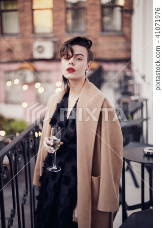 Stylish woman is standing on the balcony Stylish woman is standing on the balcony 41071976