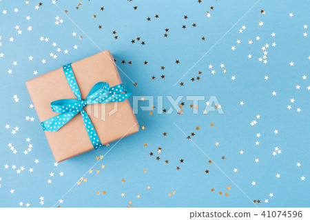 Gift box wrapped in kraft paper with confetti. 41074596