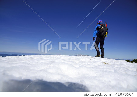 Climber walking on a snowy mountain Climber walking on a snowy mountain 41076564