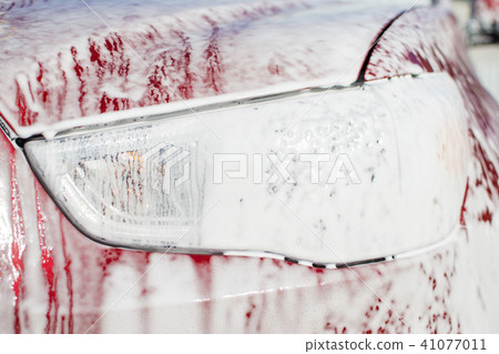 Car wash with a non-contact foam, headlight with a thick foam close-up 41077011