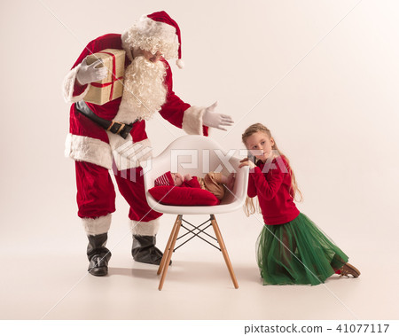 Christmas portrait of cute little newborn baby girl, dressed in christmas clothes, studio shot Christmas portrait of cute little newborn baby girl, dressed in christmas clothes, studio shot 41077117