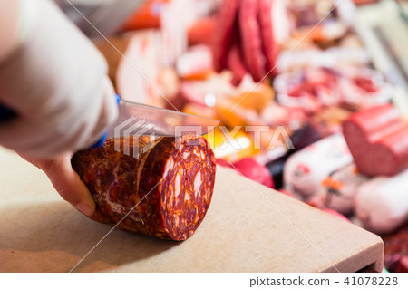 Butcher woman cutting chorizo sausage Butcher woman cutting chorizo sausage 41078228
