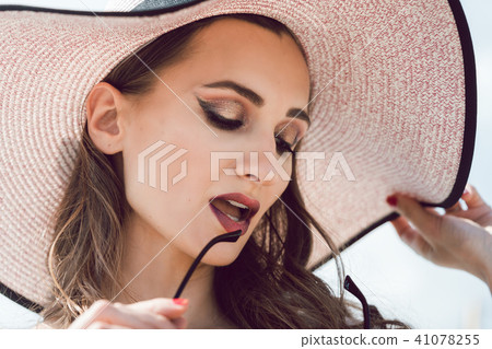 Woman on the sea with sun hat and sunglasses 41078255