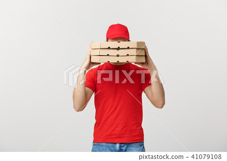 A Deliveryman hidden behind a large stack of pizza boxes he is carrying. Isolated over grey A Deliveryman hidden behind a large stack of pizza boxes he is carrying. Isolated over grey 41079108
