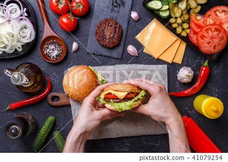 Photo on top of two hamburgers, human hands, chili peppers, 41079254