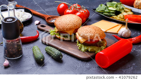 Photo of two hamburgers on wooden board, cheese 41079262