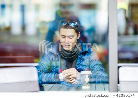 Smilling man with a cup of coffee in a cafe. 41080174