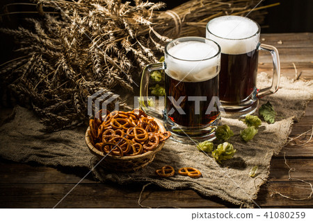 Two tankard beer with wheat and hops , basket of pretzels Two tankard beer with wheat and hops , basket of pretzels 41080259