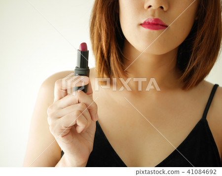 portrait young woman applying or wearing lipstick 41084692