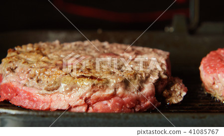 Beefsteaks frying on a grill - front view Beefsteaks frying on a grill - front view 41085767