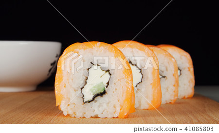 Sushi in a row on a wooden plate Sushi in a row on a wooden plate 41085803