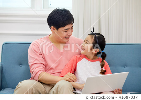 Dad spending holiday on laptop with living room sofa with daughter 41087037