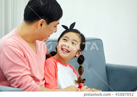 Dad spending holiday on laptop with living room sofa with daughter 41087052