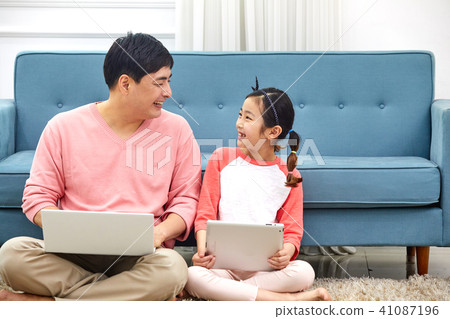 Dad spending holiday on laptop with living room sofa with daughter 41087196