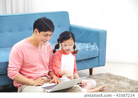 Dad spending holiday on laptop with living room sofa with daughter Dad spending holiday on laptop with living room sofa with daughter 41087214