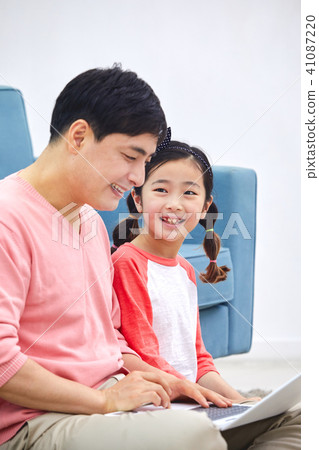Dad spending holiday on laptop with living room sofa with daughter 41087220