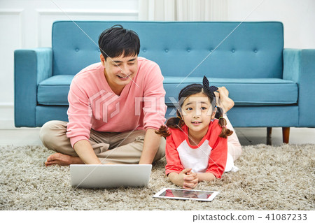 Dad spending holiday on laptop with living room sofa with daughter 41087233