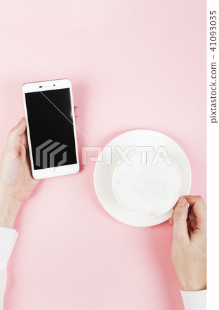 Woman holds phone and drink coffee 41093035