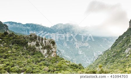 Mountain cliffs against sky with clouds 41094703