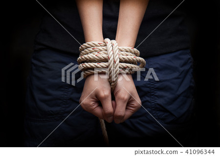 Hands of a victim woman tied up with rope  41096344