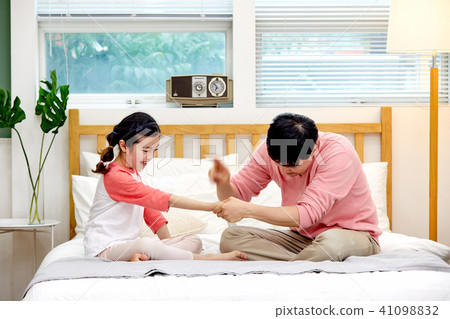 Dad and daughter playing rock scissors in bed Dad and daughter playing rock scissors in bed 41098832