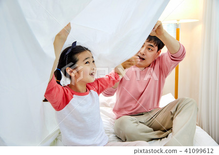 A loving daughter and a caring father playing under the bed covers 41099612