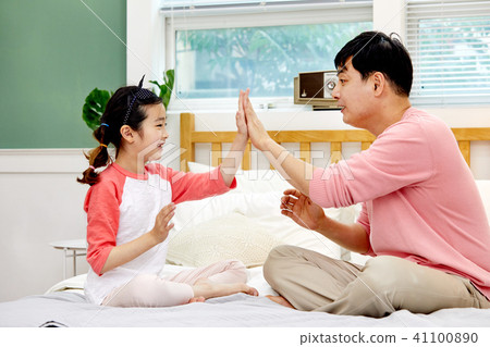 Dad and daughter playing rock scissors in bed 41100890
