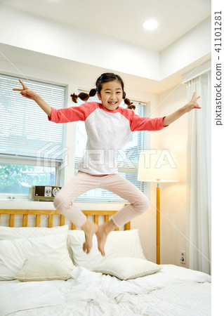 一個可愛的女兒在床上跳 41101281
