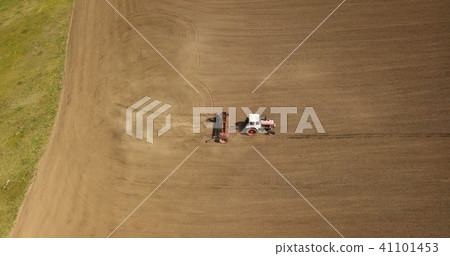 Aerial view of tractor mowing brown field Aerial view of tractor mowing brown field 41101453