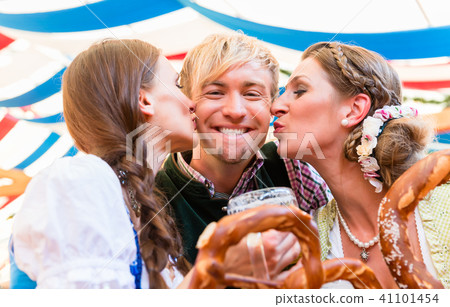 Two women kissing man at Bavarian beer tent Two women kissing man at Bavarian beer tent 41101454